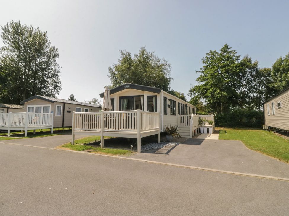 A static caravan with a deck and garden area at Hedgerow Lodge Haven Lakeside near Grange-Over-Sands