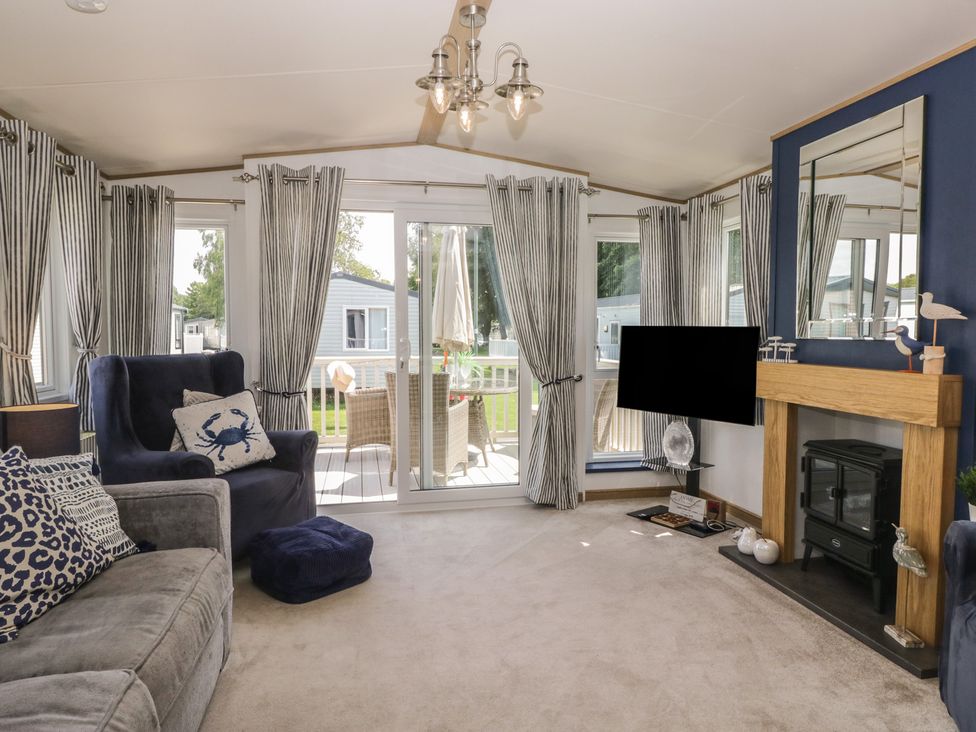 A living room with a sofa and TV at Hedgerow Lodge in Haven Lakeside near Grange-Over-Sands