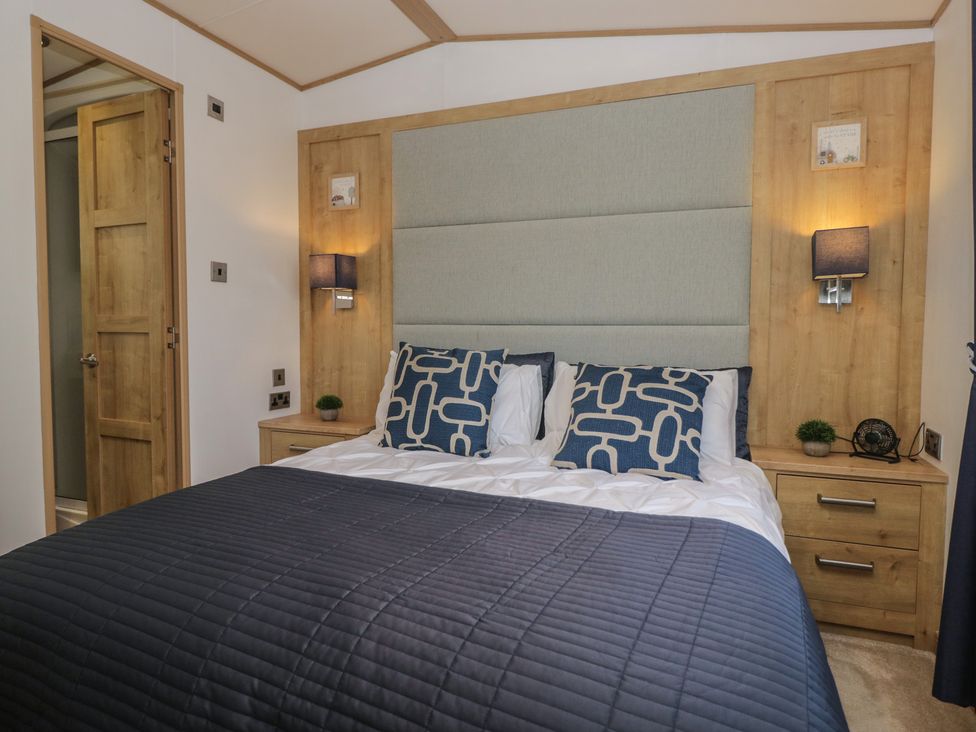 A bedroom with a bed and bedside tables at Hedgerow Lodge Haven Lakeside near Grange-Over-Sands