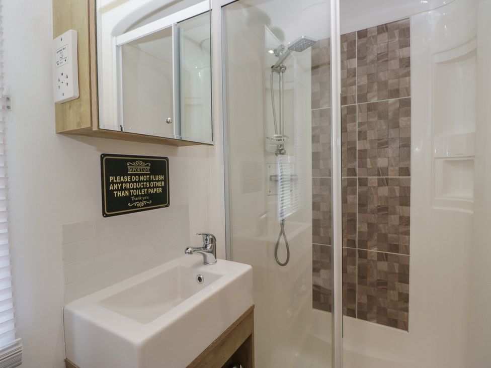 A bathroom with a shower and sink at Hedgerow Lodge Haven Lakeside near Grange-Over-Sands