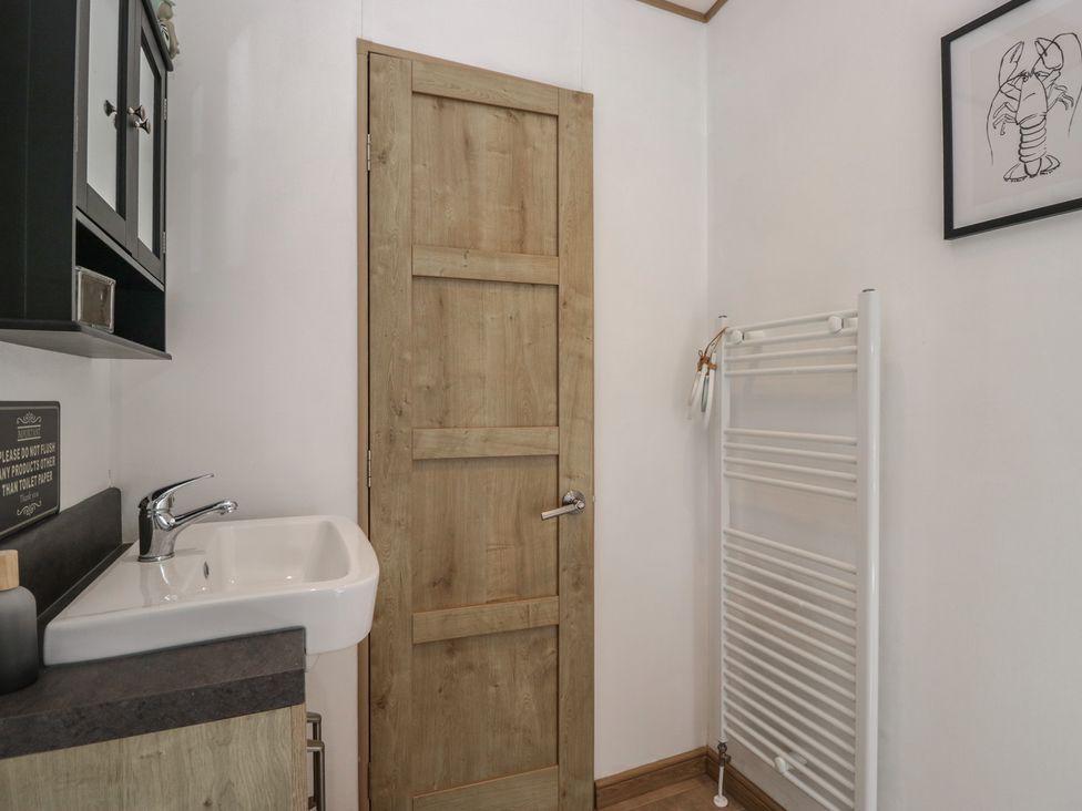 A bathroom with a sink and towel rail at Hedgerow Lodge Haven Lakeside near Grange-Over-Sands