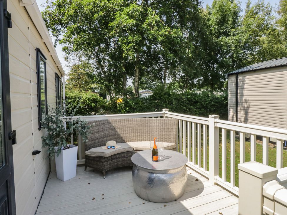 An outdoor area with a table and seating at Hedgerow Lodge near Haven Lakeside