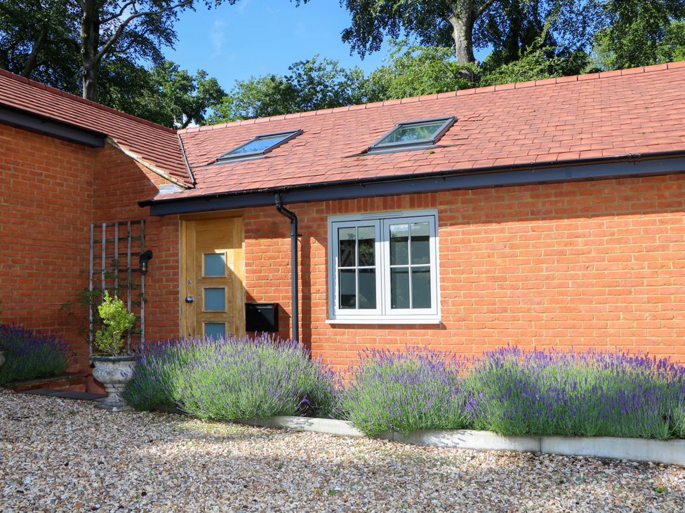 An exterior view of a house with a door and window at Keepers Cottage, Petersfield