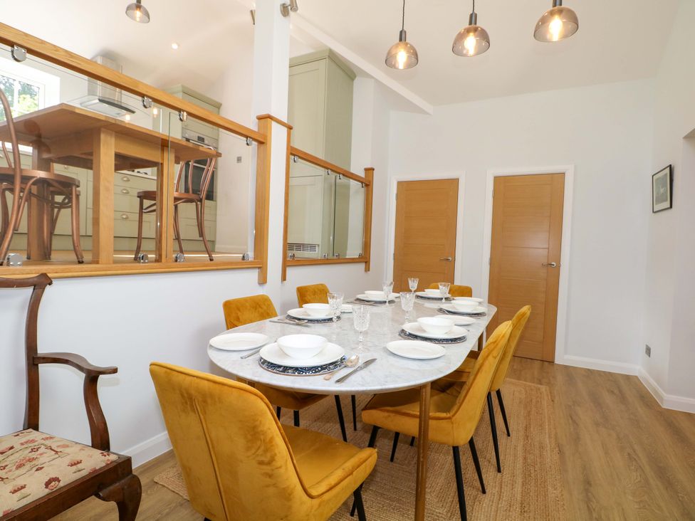 A dining room with a table set for meals at Keepers Cottage Petersfield