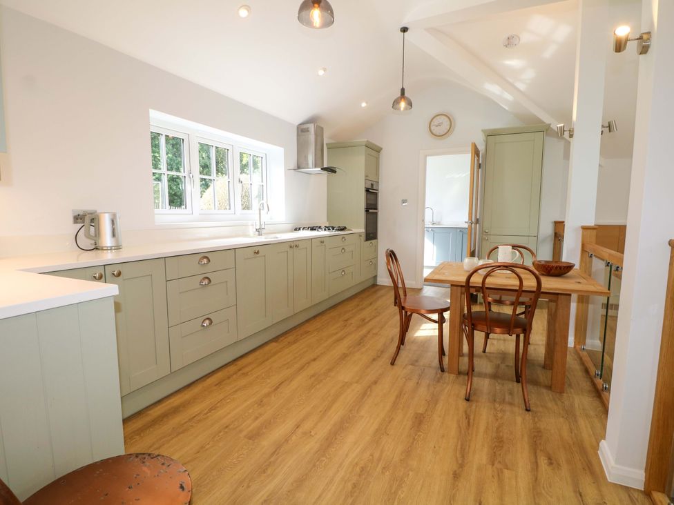 A kitchen with a table and chairs at Keepers Cottage in Petersfield