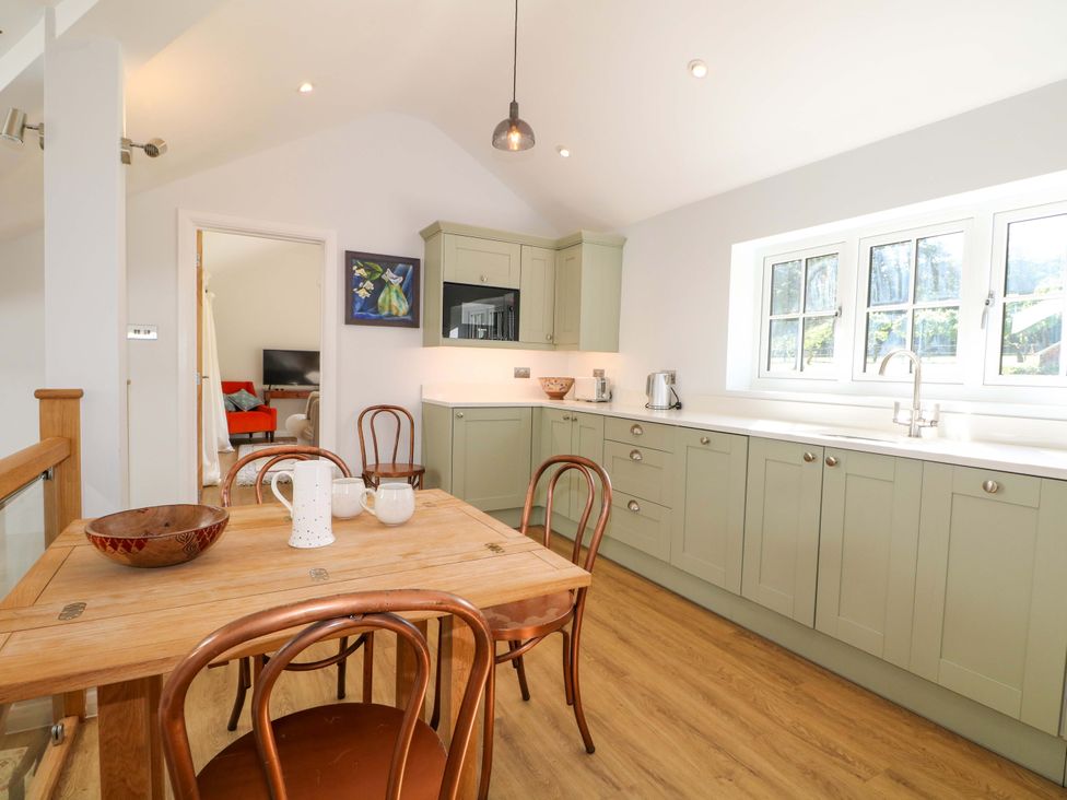 A kitchen with a table and chairs at Keepers Cottage in Petersfield