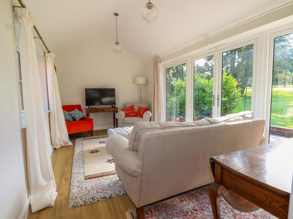 A living room with furniture and a television at Keepers Cottage in Petersfield