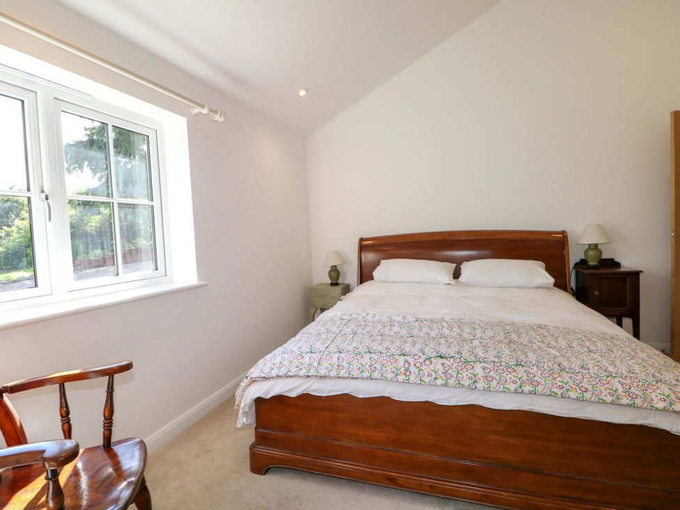 A bedroom with a bed and window at Keepers Cottage, Petersfield