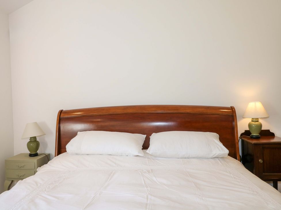 A bedroom with a bed and lamps at Keepers Cottage in Petersfield
