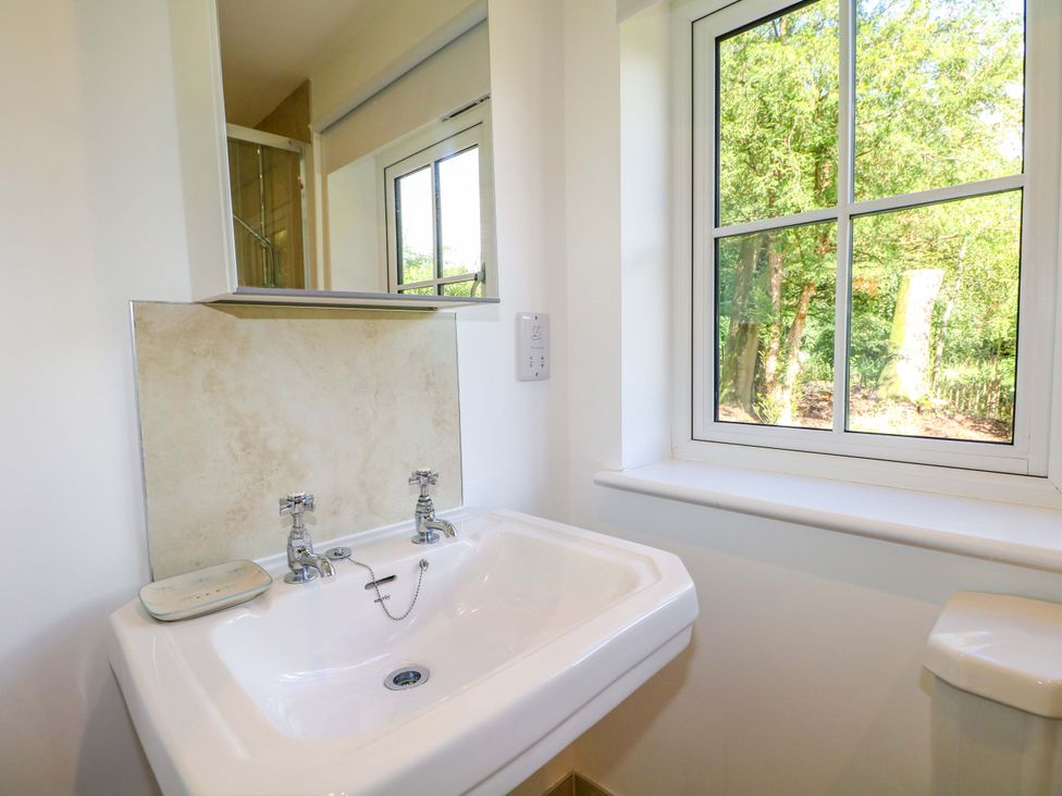 A bathroom with a sink and window at Keepers Cottage in Petersfield