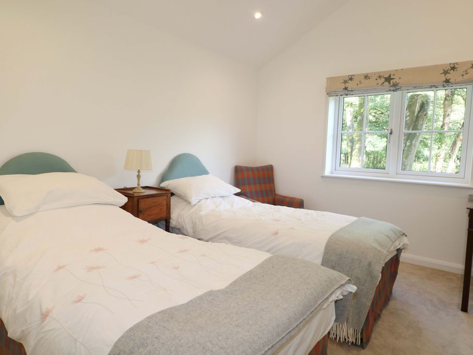 A bedroom with twin beds and a window at Keepers Cottage in Petersfield