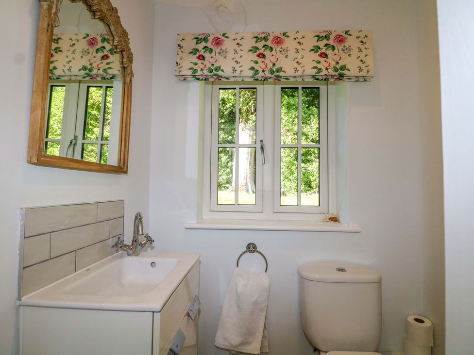 A bathroom with a sink and mirror at Keepers Cottage in Petersfield