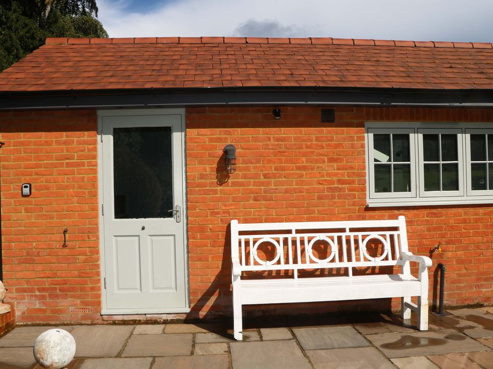 An entrance with a bench and door at Keepers Cottage Petersfield