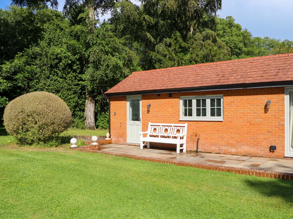 A house with a bench and garden at Keepers Cottage in Petersfield