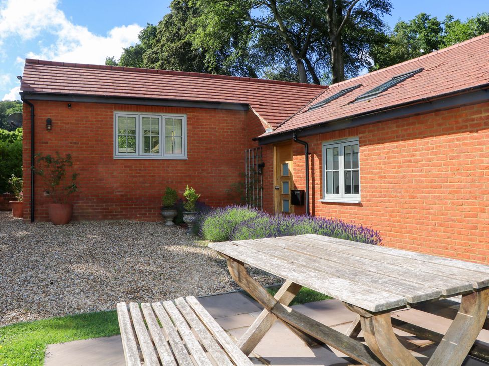 An outdoor seating area with a picnic table at Keepers Cottage in Petersfield