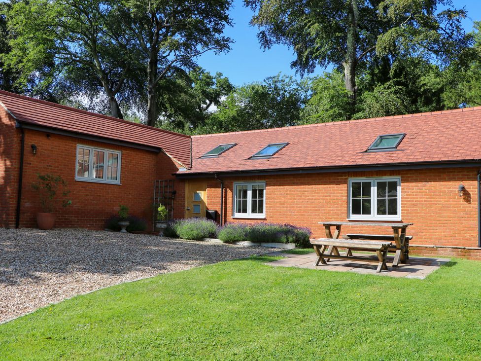 A house with a table and chairs in the garden at Keepers Cottage in Petersfield