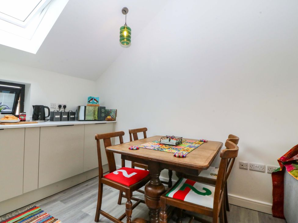 A kitchen with a table and chairs at Trwyn Cam Brynrefail near Llanberis