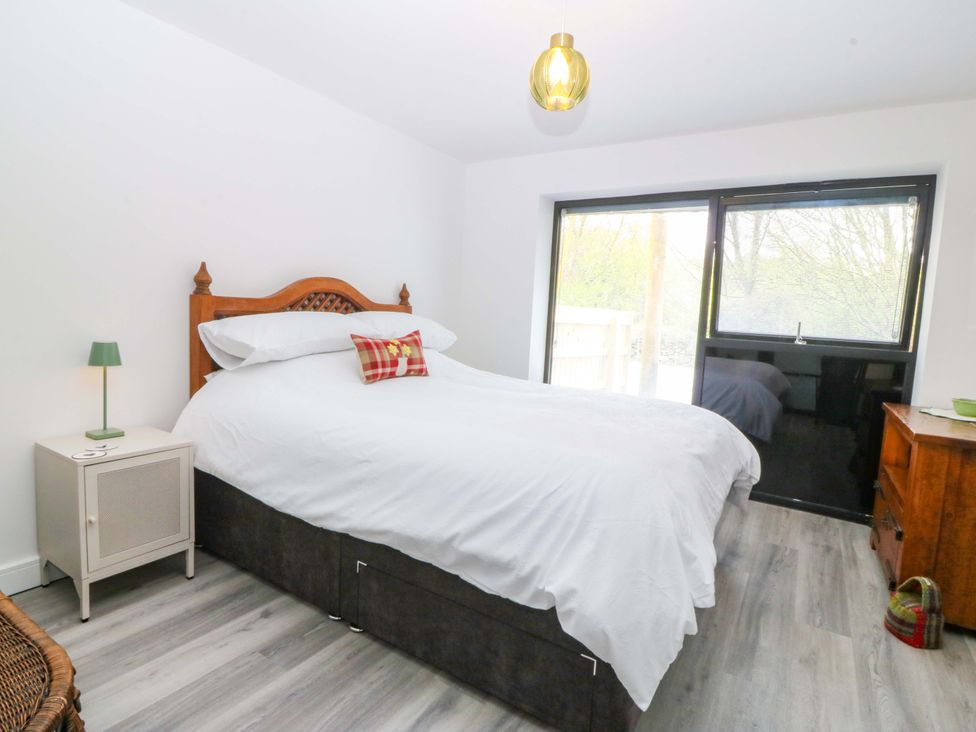 A bedroom with a bed and nightstand at Trwyn Cam in Brynrefail near Llanberis
