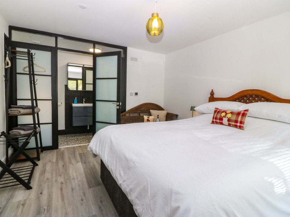 A bedroom with a bed and wardrobe at Trwyn Cam Brynrefail near Llanberis