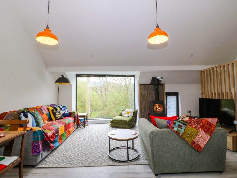 A living room with a sofa and coffee table at Trwyn Cam in Brynrefail near Llanberis