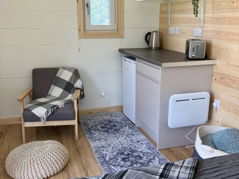 A kitchen space with an armchair and appliances at Sherwood - Cosy Pod 3 in Mansfield