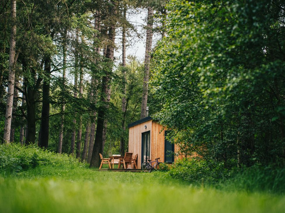 A cabin with a table and chairs next to a bicycle at Sherwood - Cosy Pod 6 Mansfield