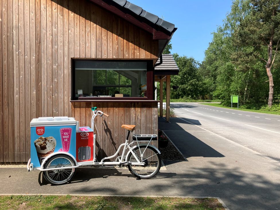 An ice cream bike parked outside a wooden building by the road at Sherwood - Cosy Pod 6 Mansfield