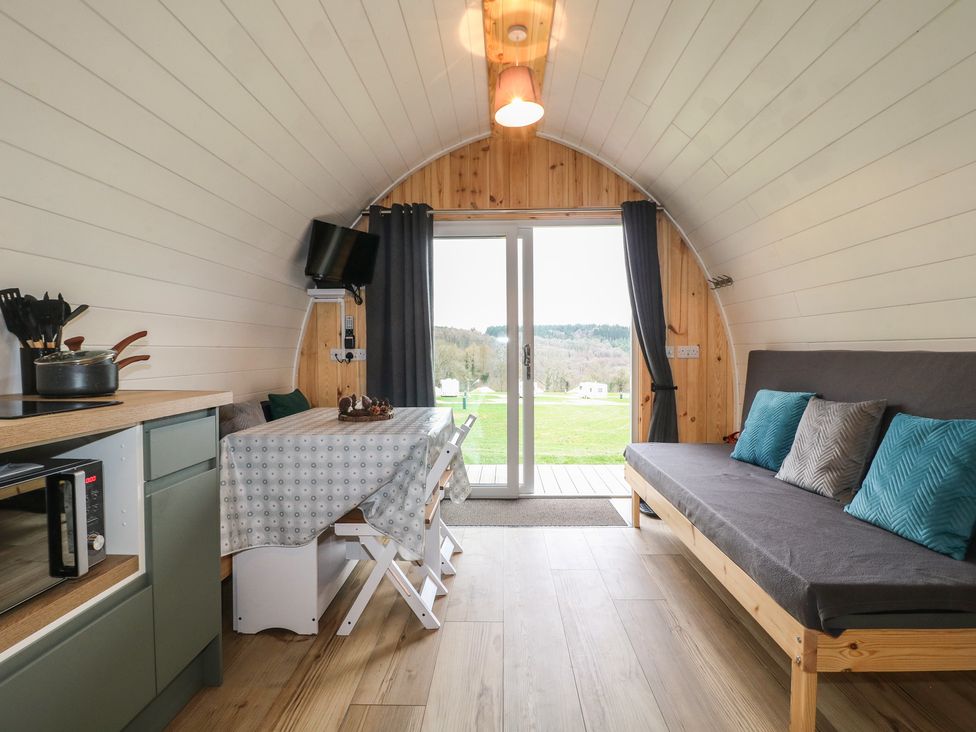 A living room with kitchen countertop and dining table at Bracelands - Deluxe Pod 6 Coleford