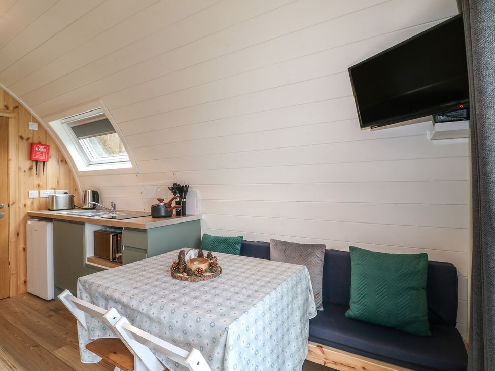 A kitchen area with a table and seating at Bracelands - Deluxe Pod 6 in Coleford