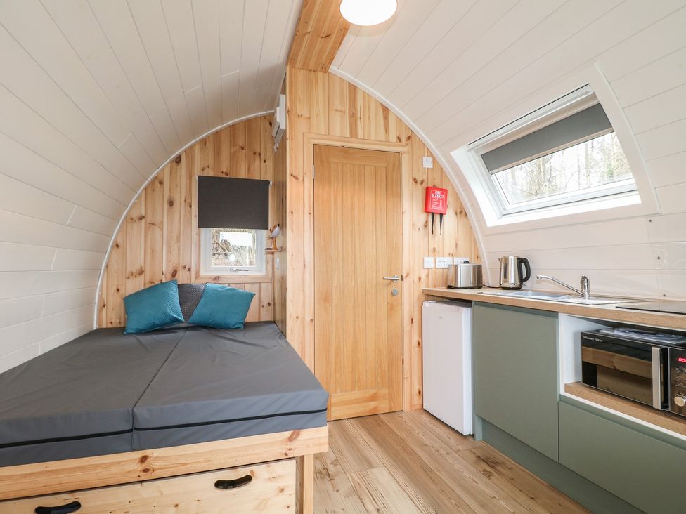 A pod interior with a bed and kitchen area at Bracelands - Deluxe Pod 6 in Coleford