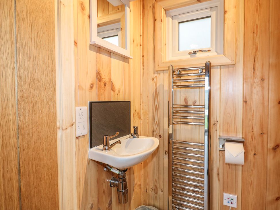 A bathroom featuring a sink, mirror, towel radiator at Bracelands - Deluxe Pod 6, Coleford