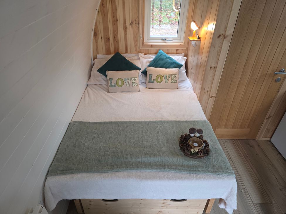 A bedroom with a bed and pillows at Bracelands - Deluxe Pod 6 in Coleford