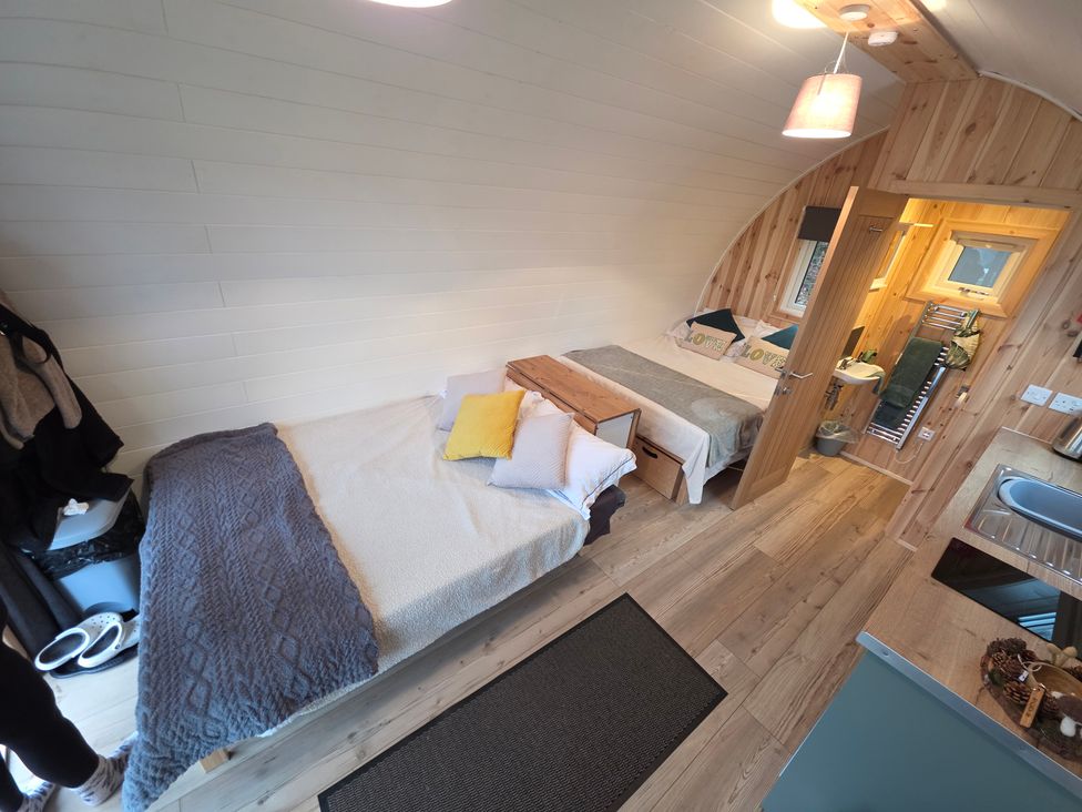 Two beds with pillows and a wooden table in Bracelands - Deluxe Pod 7 Coleford