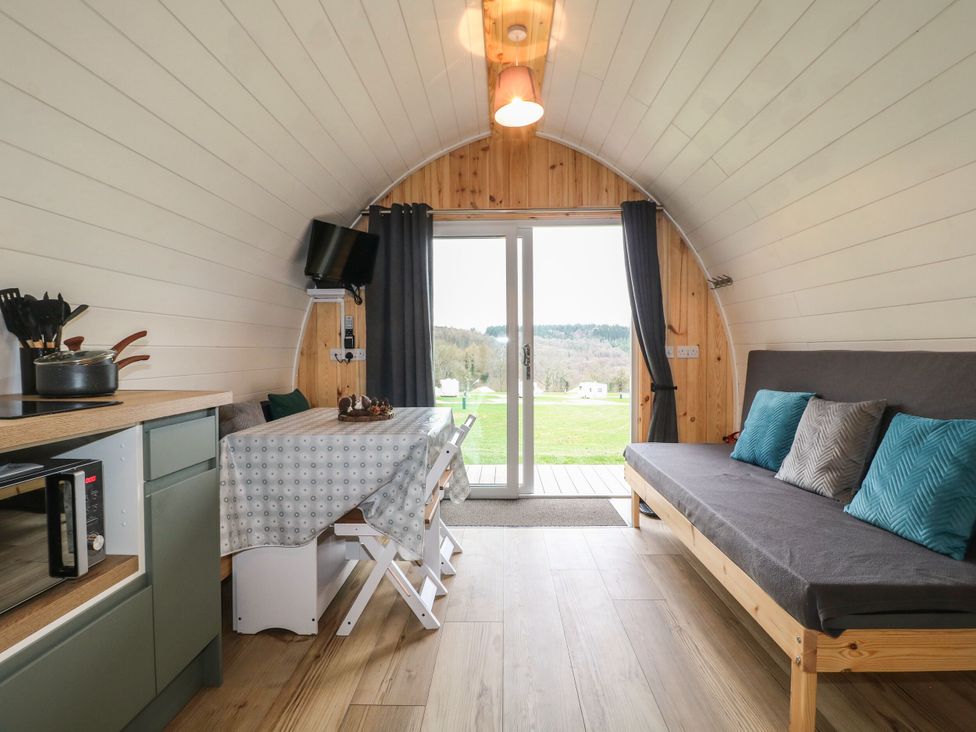 A living room with a sofa, table and television at Bracelands - Deluxe Pod 7 near Coleford