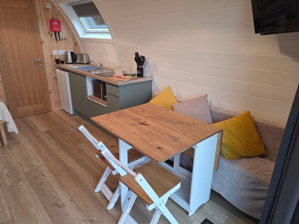 A kitchen with a dining table and chairs at Bracelands - Deluxe Pod 8 Coleford