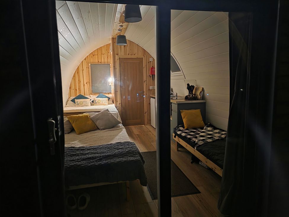 A bedroom with a bed and kitchenette at Bracelands - Deluxe Pod 8 in Coleford