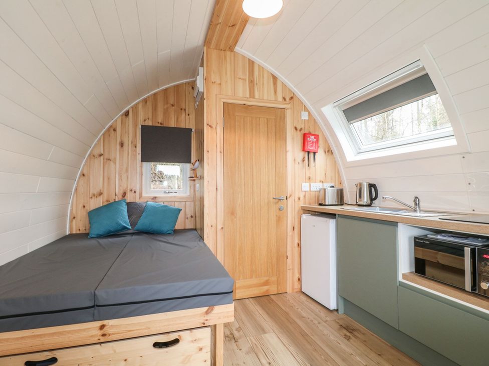 A bedroom with a bed and kitchen unit at Bracelands - Deluxe Pod 8 near Coleford