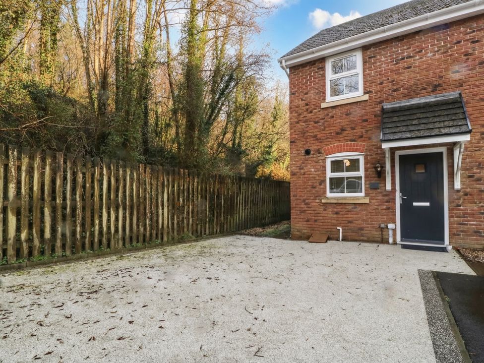 An outdoor view of a house with a pathway and a wooden fence at 42 Ynys Y Nos in Glynneath
