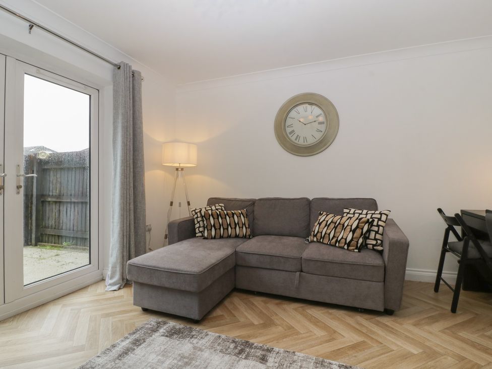 A living room with a sofa and clock at 42 Ynys Y Nos Glynneath