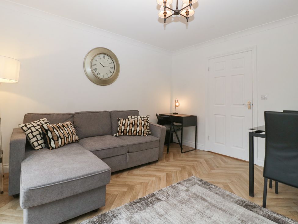 A living room with a sofa and desk at 42 Ynys Y Nos in Glynneath