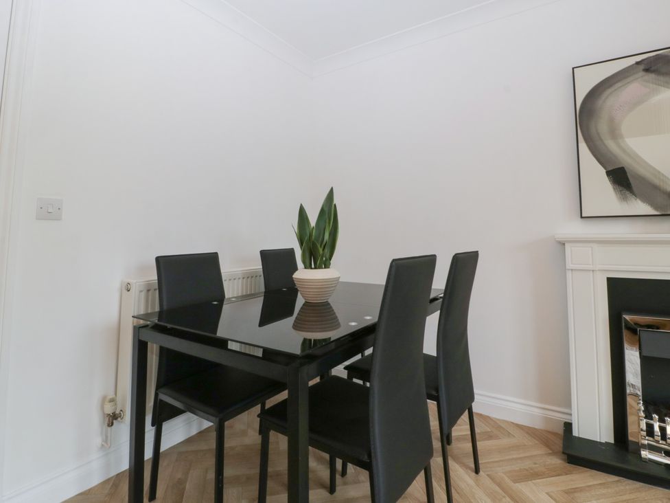 A dining room with a table and chairs at 42 Ynys Y Nos in Glynneath