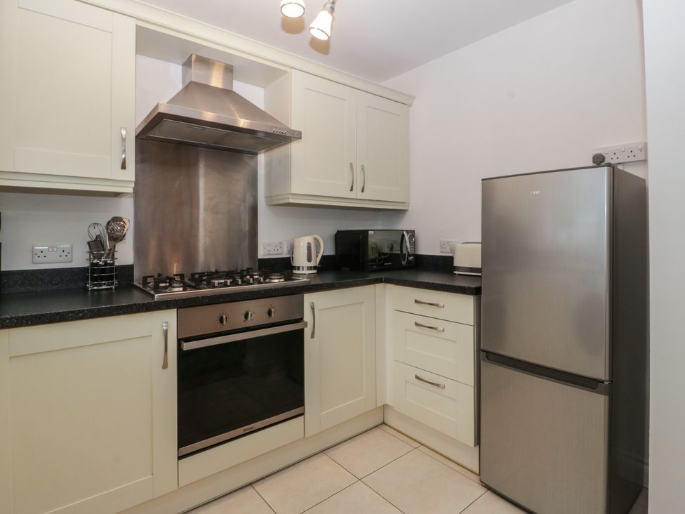 A kitchen with appliances including an oven and refrigerator at 42 Ynys Y Nos Glynneath