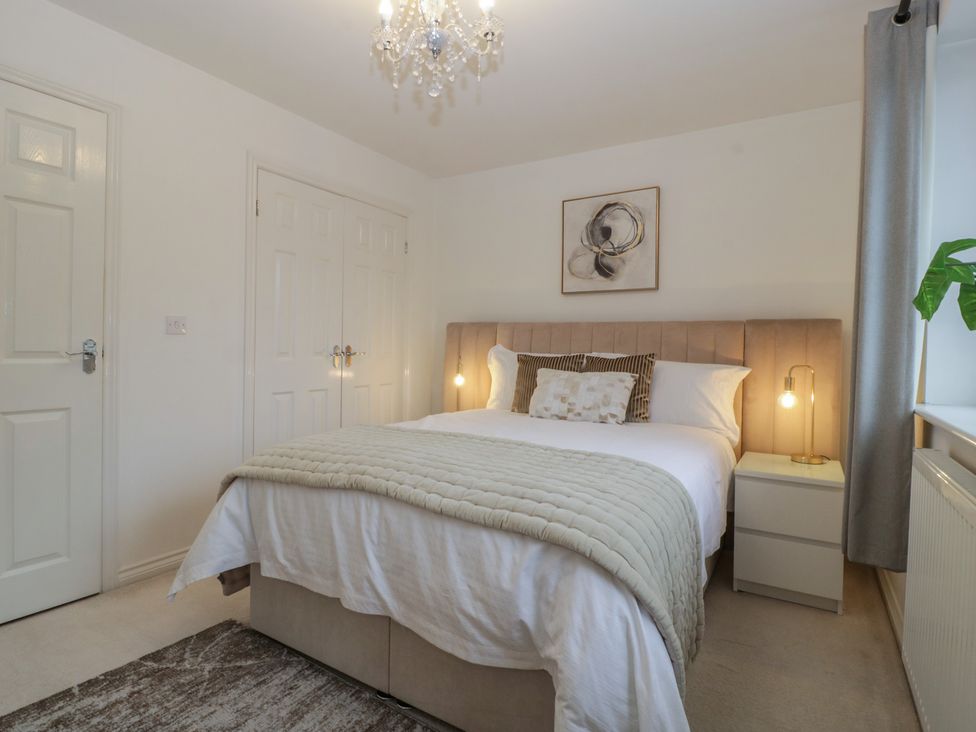 A bedroom with a bed and nightstand at 42 Ynys Y Nos, Glynneath