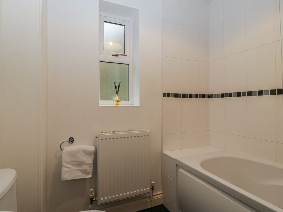 A bathroom with a bathtub and window at 42 Ynys Y Nos in Glynneath