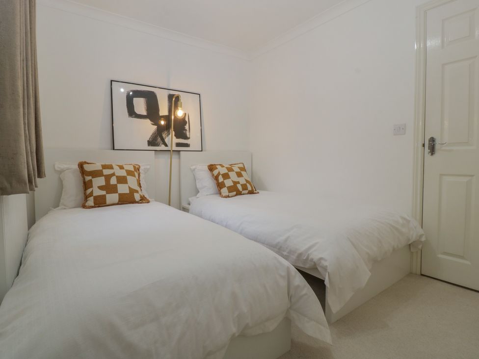 A bedroom with two beds and a lamp at 42 Ynys Y Nos in Glynneath