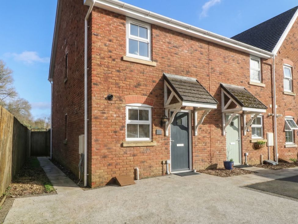 An outdoor area with a brick wall and front doors at 42 Ynys Y Nos in Glynneath