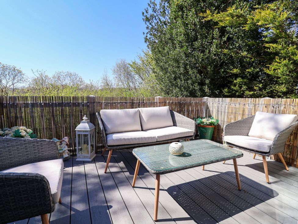 An outdoor seating area with a table and chairs at Grosvenor 10 in Llanarmon-Yn-Ial