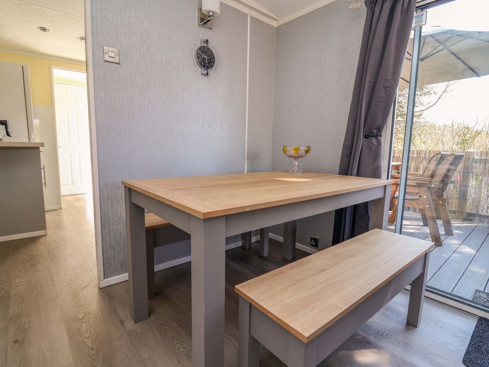 A dining room with a table and benches at Grosvenor 10 Llanarmon-Yn-Ial