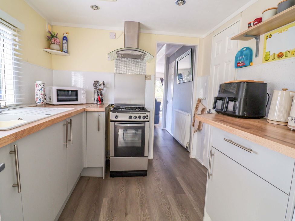 A kitchen with a cooker and microwave at Grosvenor 10 in Llanarmon-Yn-Ial