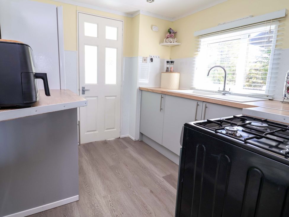 A kitchen with an air fryer and a gas stove at Grosvenor 10 in Llanarmon-Yn-Ial